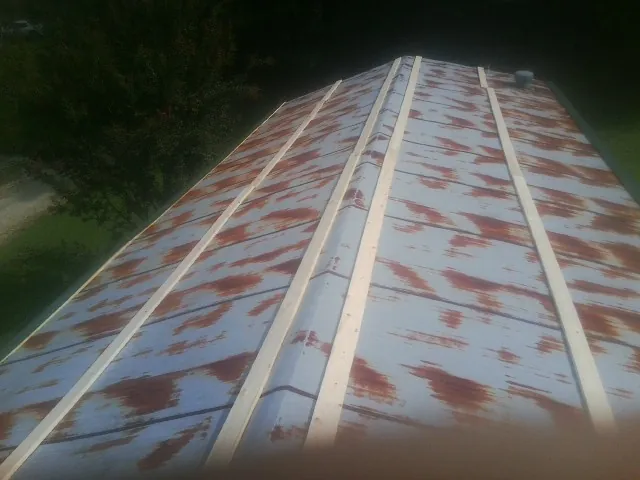Rusted metal roof panels with new wood purlins before replacement — Storm Damage Roof Repair in Leonidas by Roofing Brothers