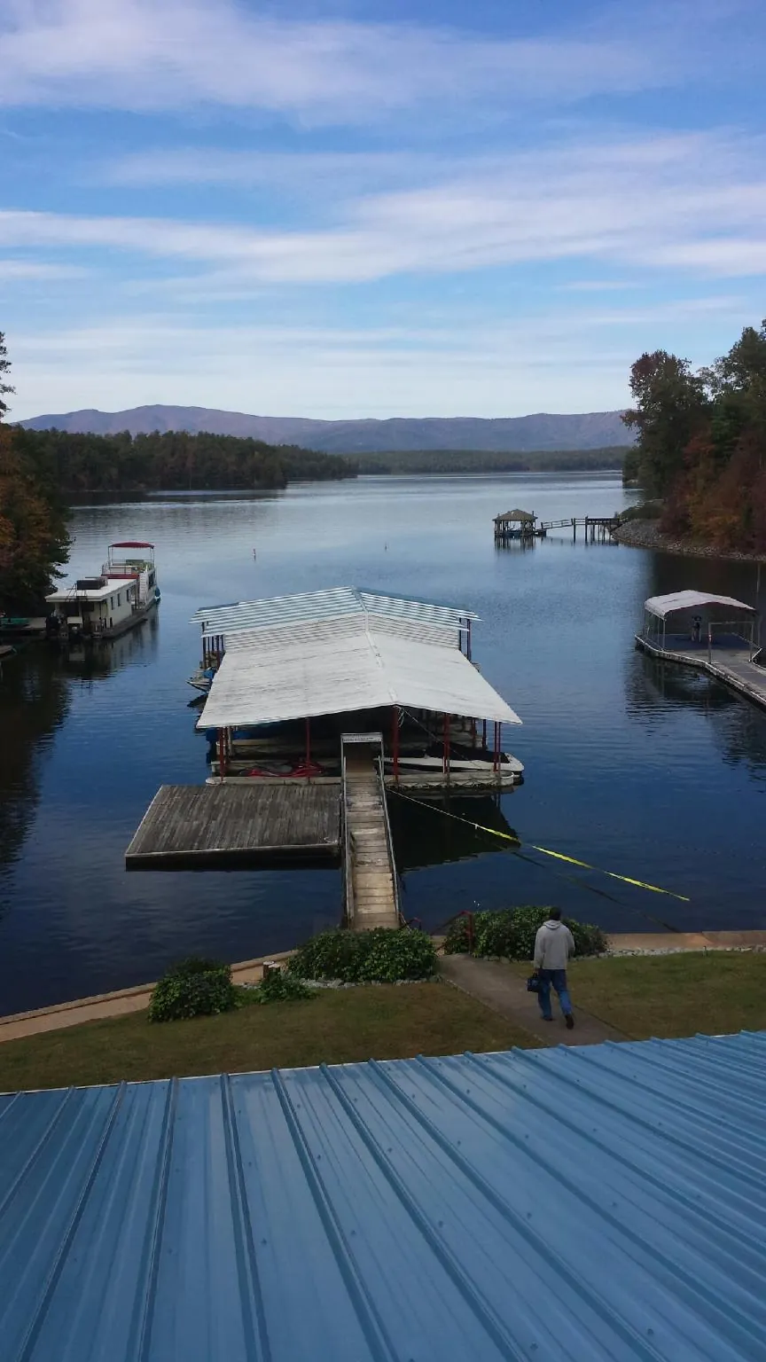 View across a lake from a newly installed blue metal roof in Leonidas