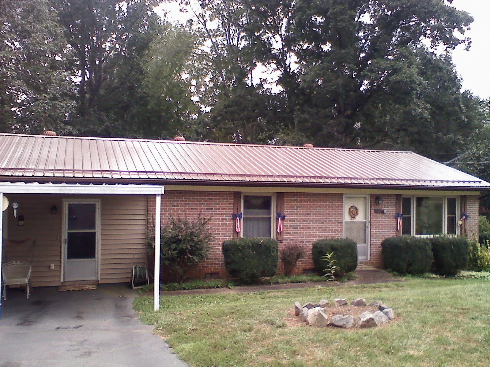 Bronze metal roof and carport on a brick ranch home — Roof Repair work by our crew in Leonidas