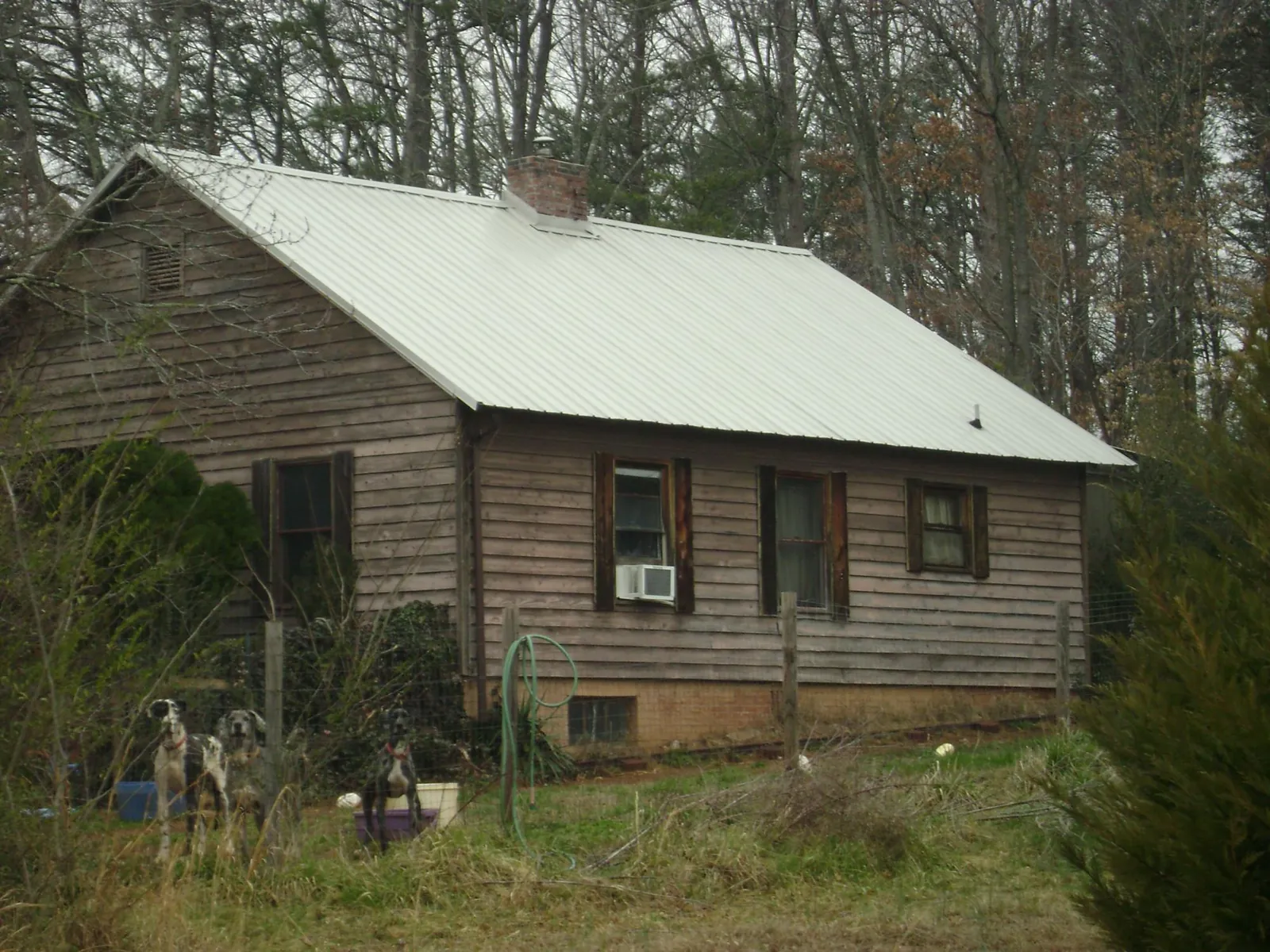 White metal roof on an old wood sided farmhouse, from a Metal Roof Installation job in Leonidas